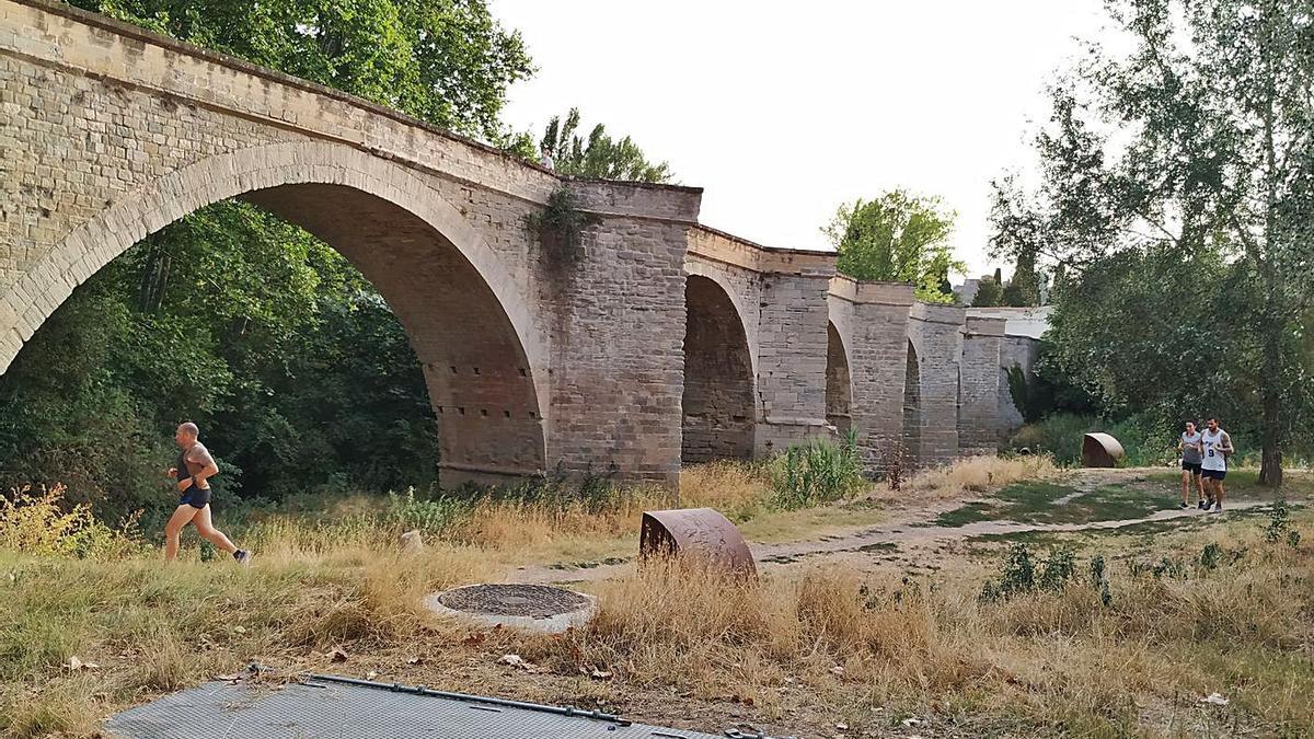 Persones corrent pel camí davant del Pont Nou | DAVID CABALLERO