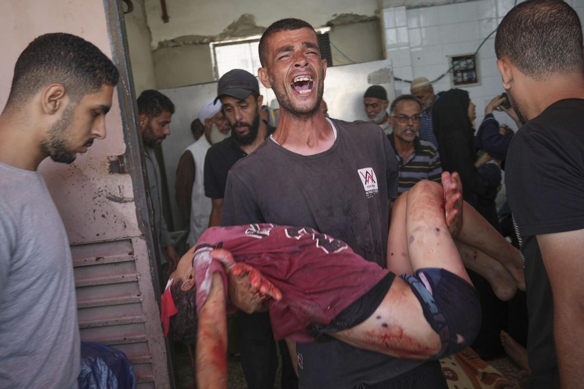 Fadi Al-Nouri carga el cuerpo de su sobrino Omar, de 11 años, quien se encontraba entre las 10 personas, incluidas dos mujeres y cinco niños, que murieron en un ataque israelí mientras esperaban recibir suplementos nutricionales en una clínica médica del Proyecto Esperanza en Deir al-Balah.