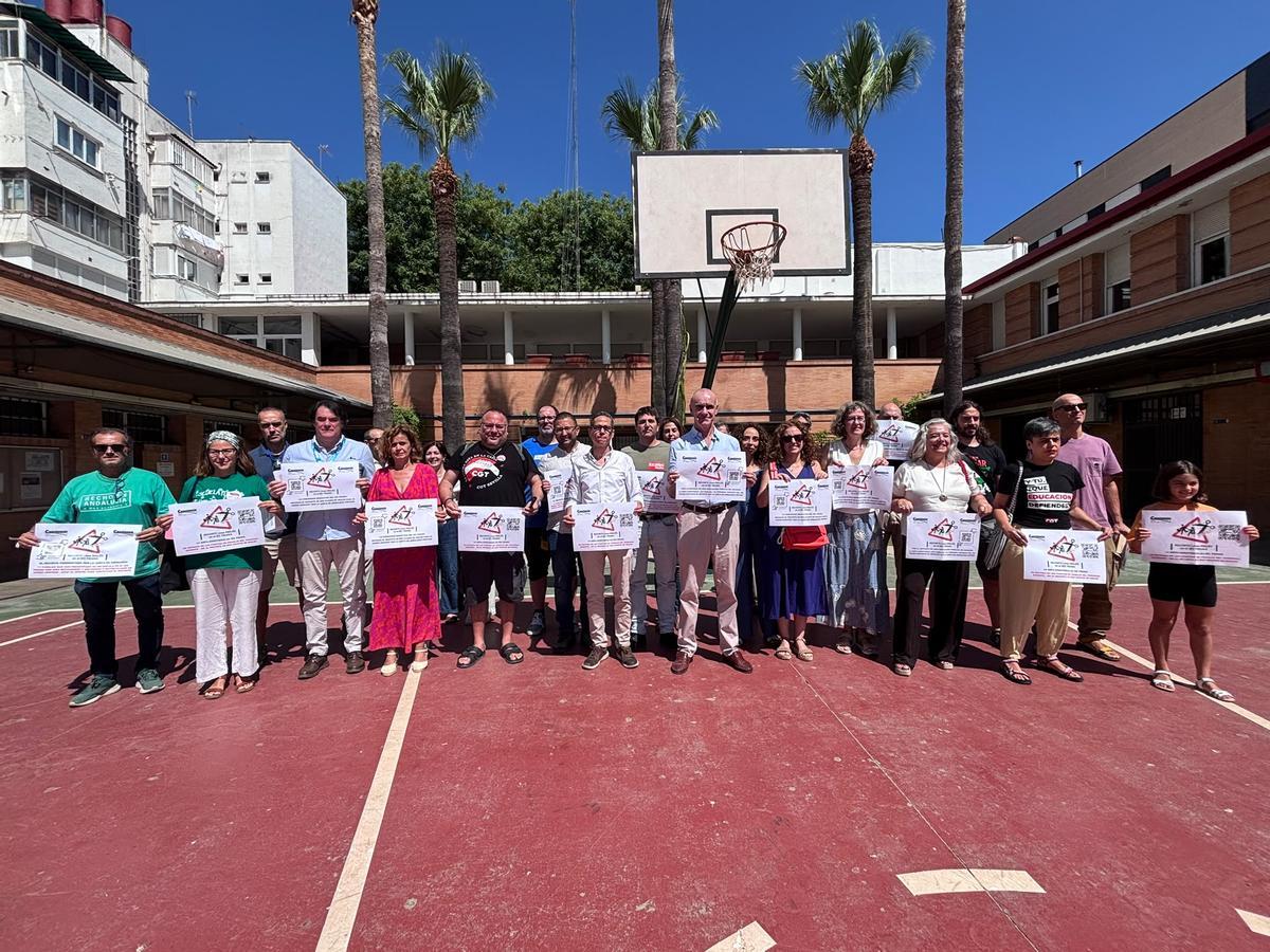 Familias y representantes de partidos políticos y sindicatos durante la concentración en el IES Triana este lunes.