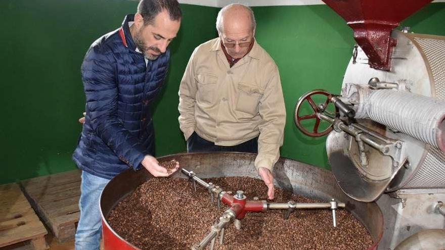 Ángel García comprueba los granos de café con Ricardo Puente.