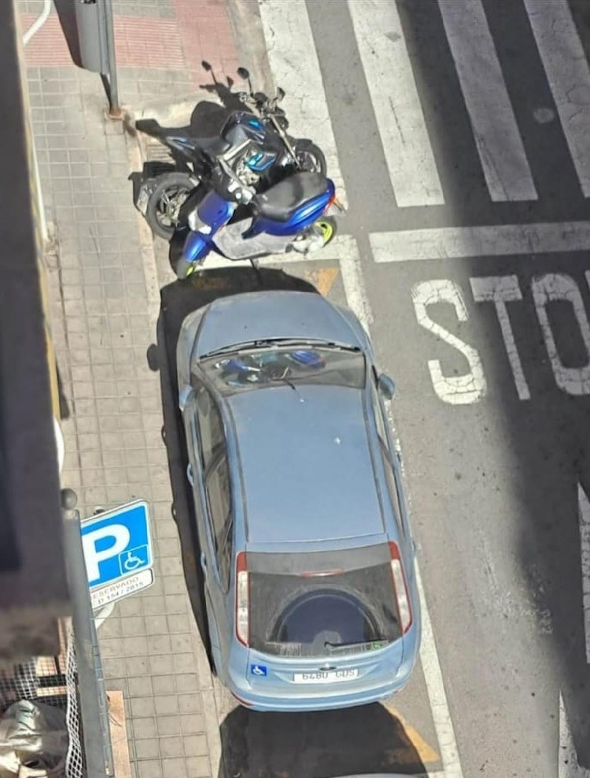 Several motorcycles parked next to the parking of an affected user in Alicante