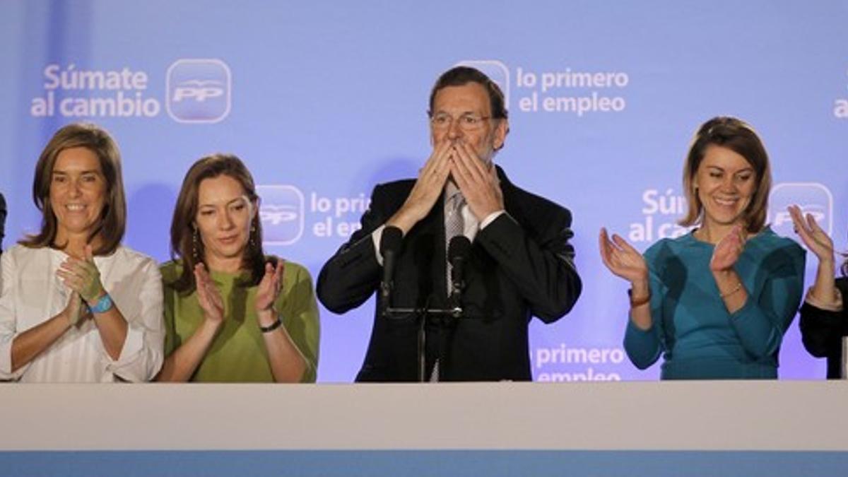 Mariano Rajoy, flanqueado por su esposa (de verde) y la plana mayor del PP, en la sede del partido.