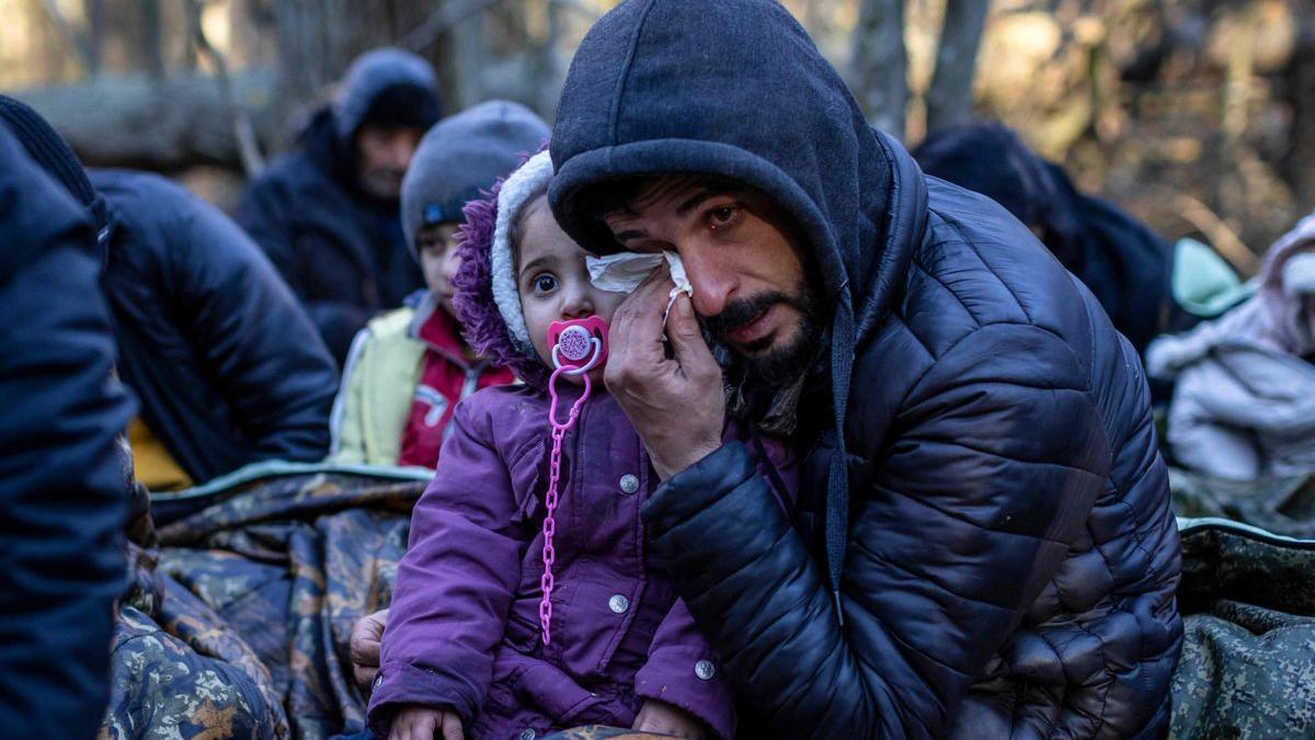 Un hombre con un niño llora, mientras espera cerca de Narewka, en la frontera.