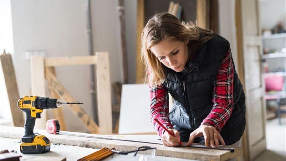 Una mujer fabricando un mueble.