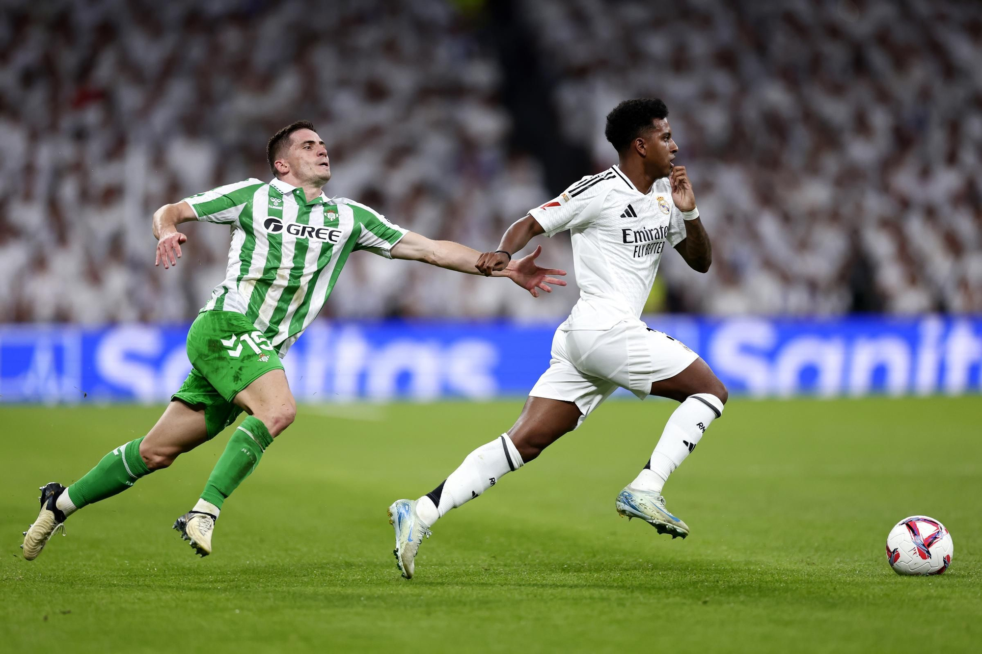 Betis' Romain Perraud, left, challenges Real Madrid's Rodrygo during the Spanish La Liga soccer match between Real Madrid and Betis at the Santiago Bernabeu stadium in Madrid, Spain, Sunday, Sept. 1, 2024. (AP Photo/Pablo Garcia)