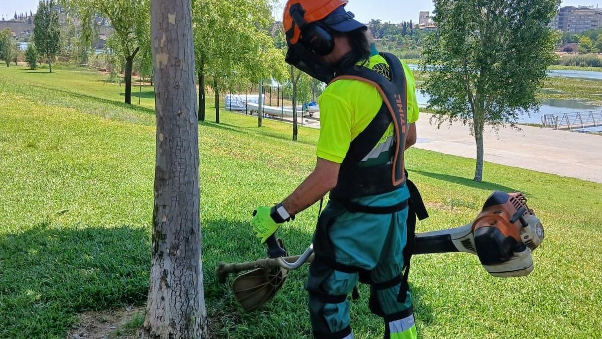 Un trabajador de mantenimiento del parque del río Guadiana con la pulsera inteligente en su muñeca.
