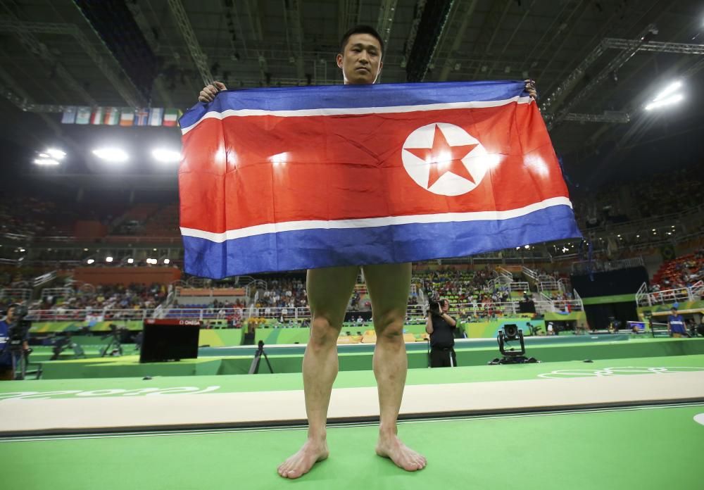 El norcoreano Ri Se Gwang muestra la bandera de su país tras ganar el oro.