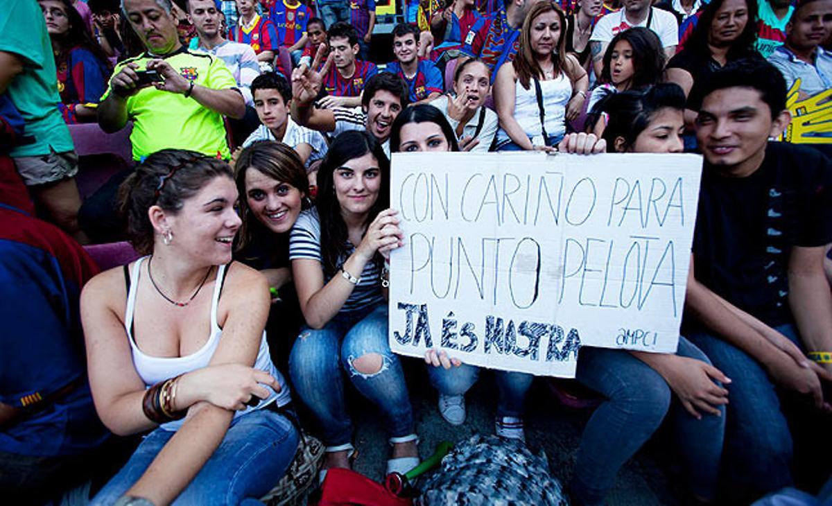 Una aficionada mostra un cartell dirigit a un programa de televisió.