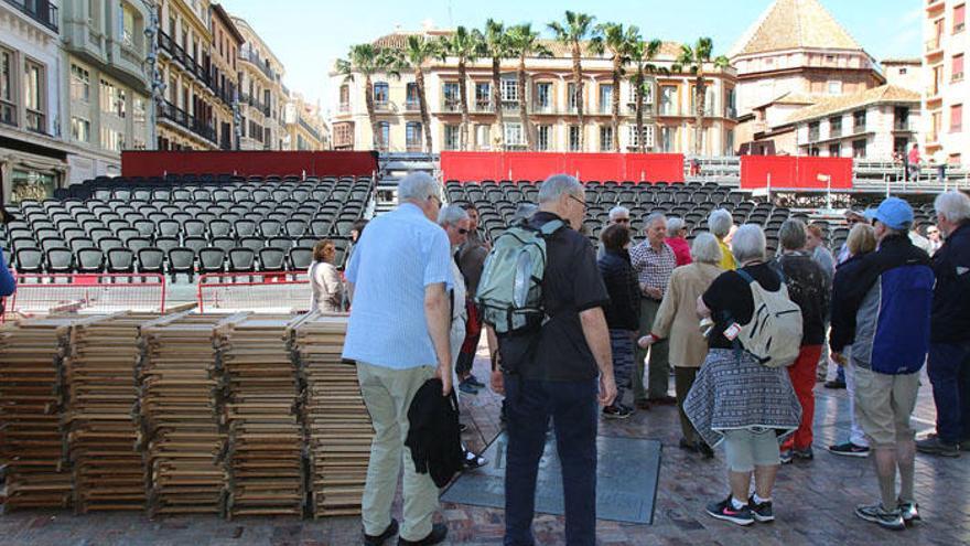 Turistas pasan por delante de la tribuna oficial.