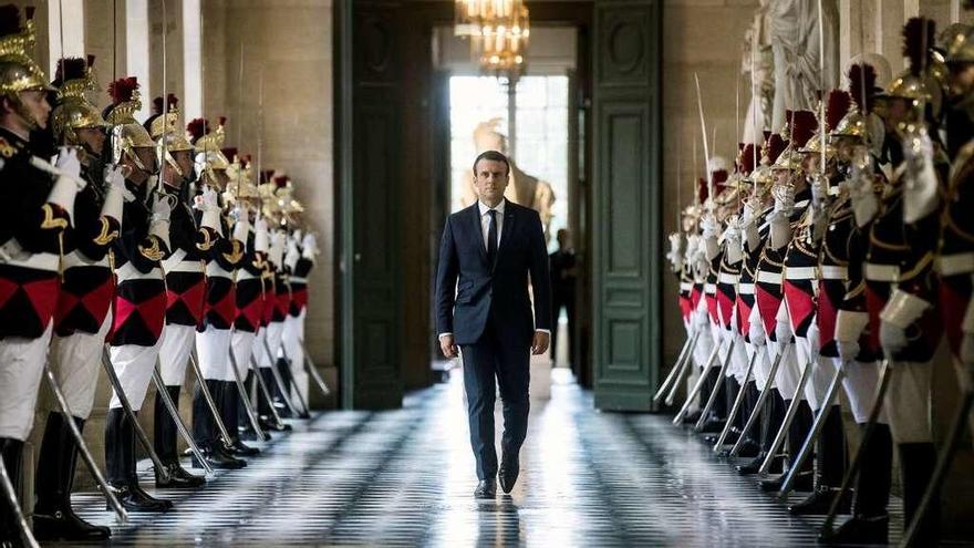 Macron atraviesa, solemne, la Galería de los Bustos rumbo al hemiciclo del palacio de Versalles. // Reuters