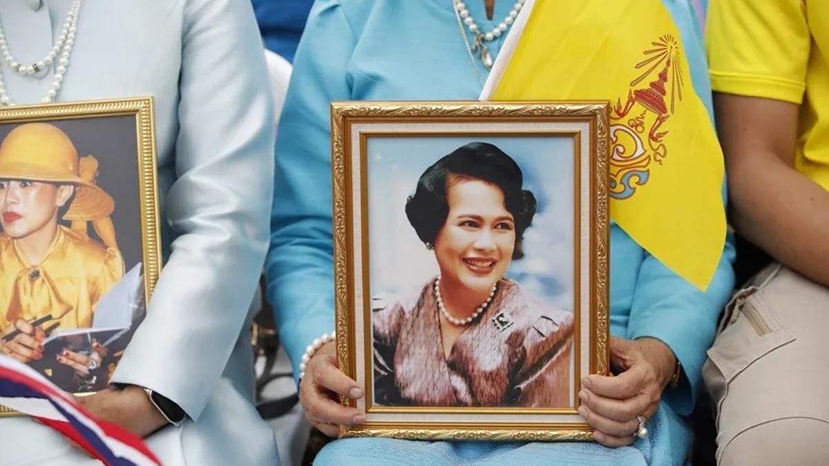 Una mujer sostiene una fotografía de la reina Sirikit, madre del rey Vajiralongkorn de Tailandia.
