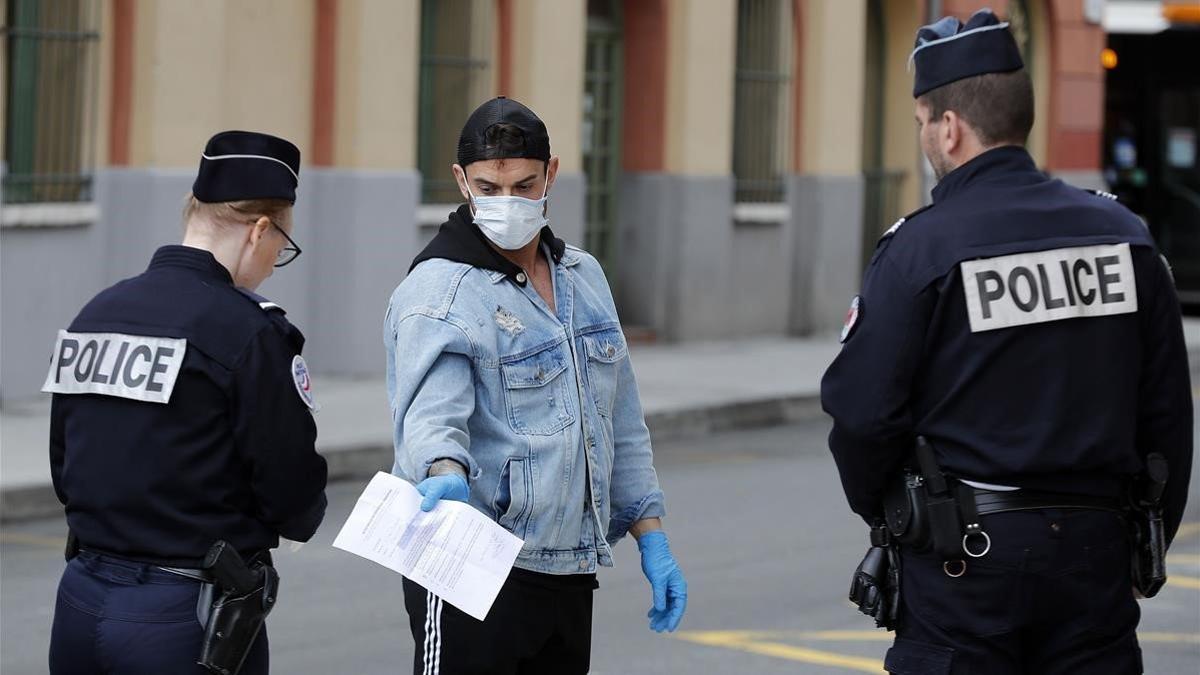 Agentes franceses reclaman a un transeúnte que justifique su desplazamiento con motivo de las restricciones por la pandemia, este lunes, en Niza.