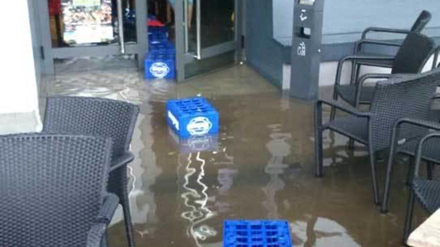 coches dañados. En las imágenes de la izquierda, los coches aparcados en La Calzada, entre riadas de agua.