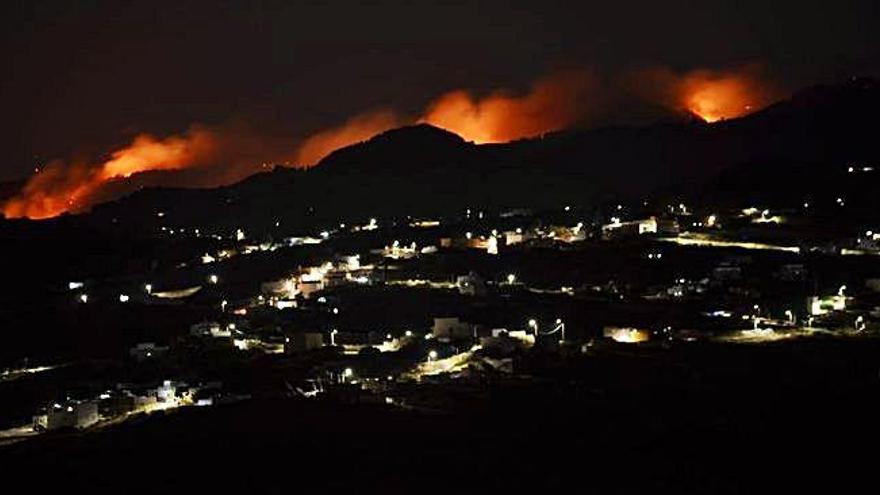 Rapidez. El incendio que se originó ayer por la tarde en Valleseco se extendió con rapidez debido que las llamas se propagaron sobre las copas de los pinos. Un hecho que hizo muy visible el fuego desde diversos puntos de la Isla, tal y como se puede apreciar en las imágenes. Sobre estas líneas, varios efectivos combaten las llamaradas.