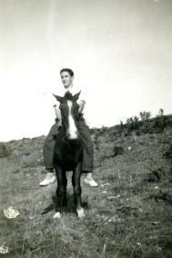 Montando en un burro durante su juventud.