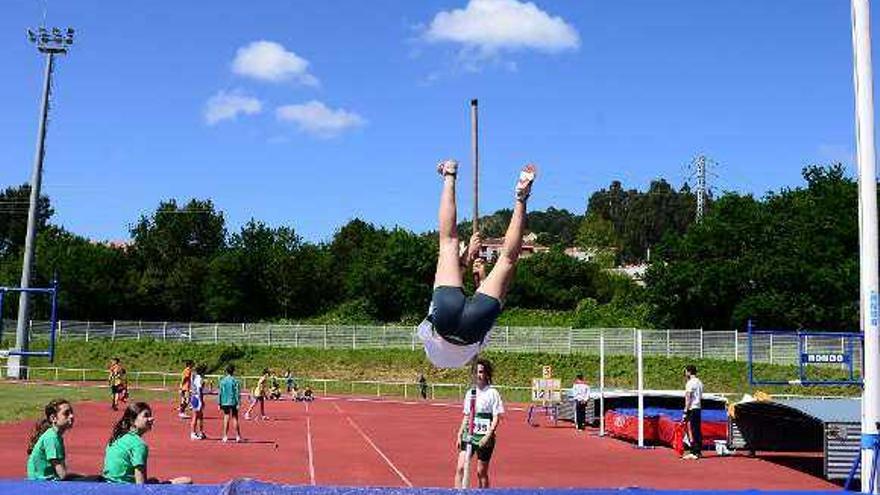 Varios niños saltan en las pistas de atletismo de Cangas.  // C.G.