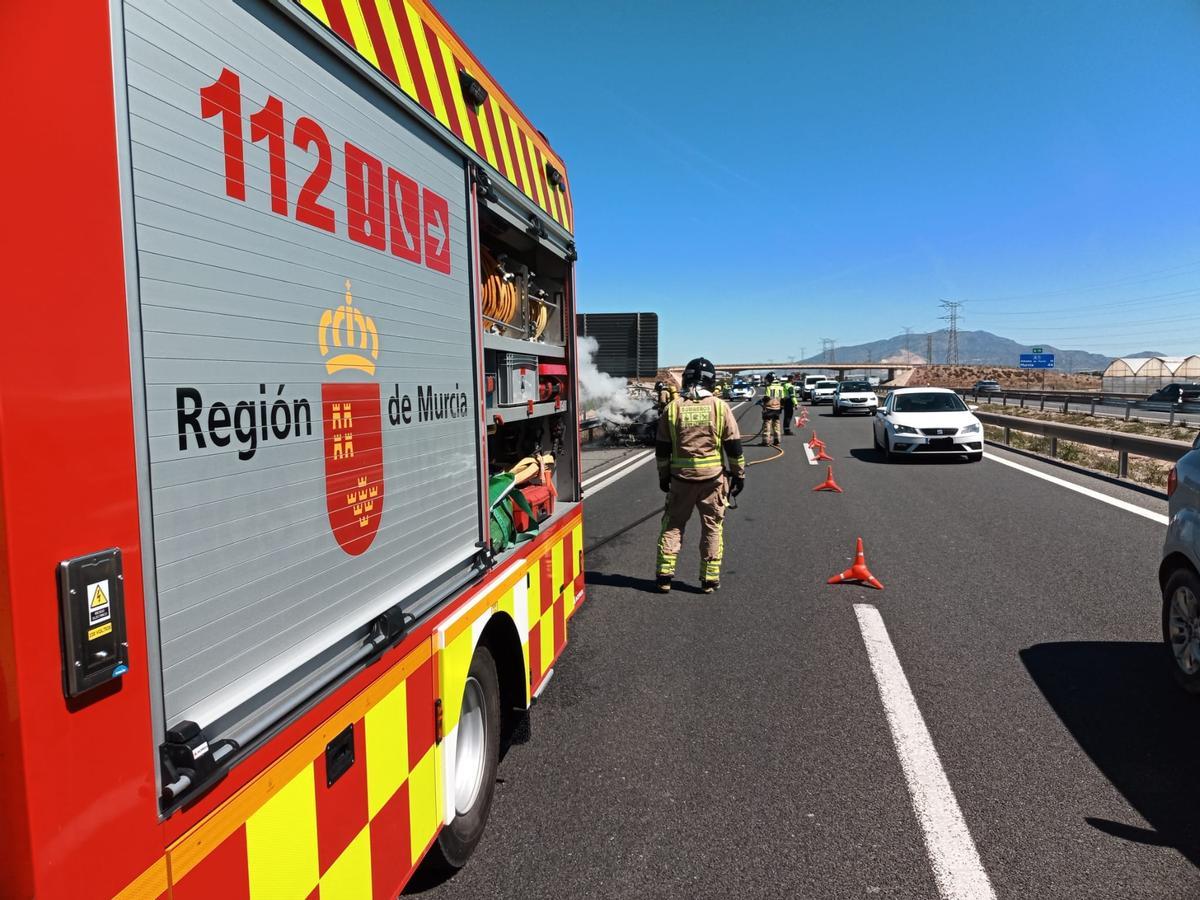 Efectivos del 1-1-2 sofocando el vehículo incendiado.
