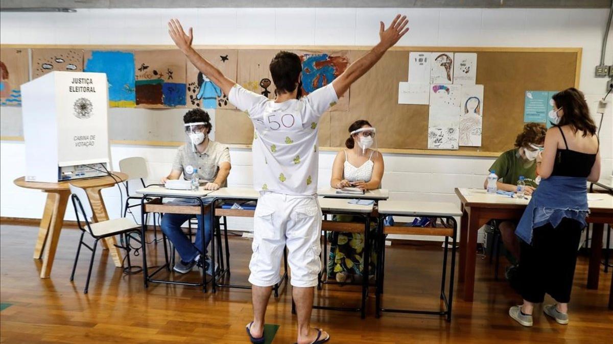 Un hombre reacciona despues de votar en las elecciones municipales hoy  en un colegio electoral en Sao Paulo (Brasil).