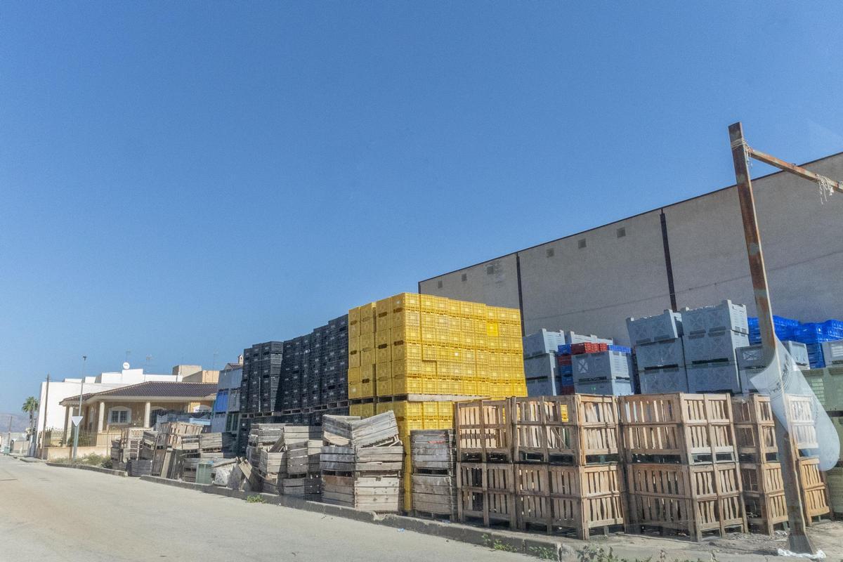 Parcela con acumulación de material de transporte de mercancías en el casco urbano de Cox