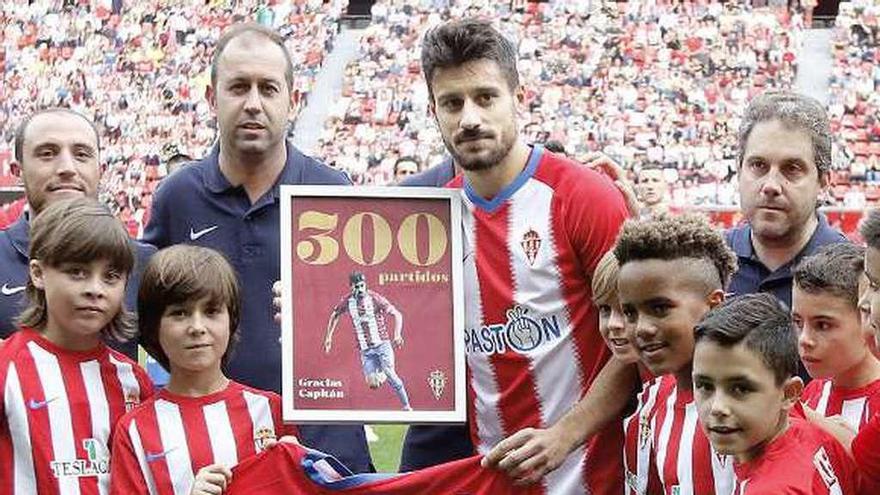 Roberto Canella posa con su camiseta y su placa conmemorativa de sus 300 partidos con el Sporting acompañado de los benjamines del club.