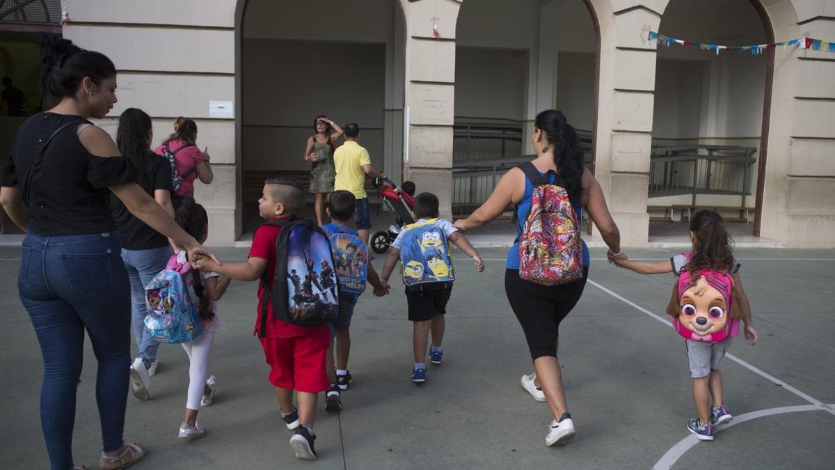 Unas madres acompañan a sus hijos al colegio.