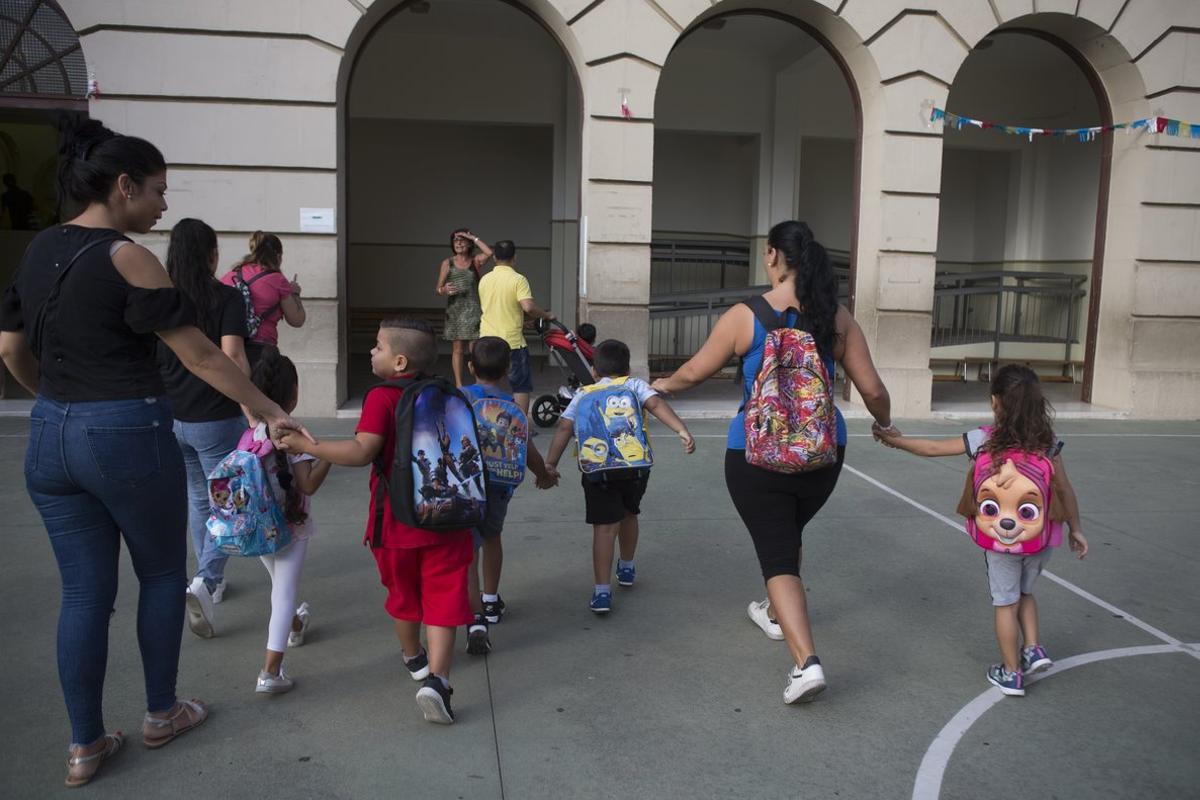 Unas madres acompañan a sus hijos al colegio.