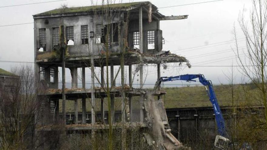 Una máquina derriba uno de los edificios del complejo de Nitrastur.
