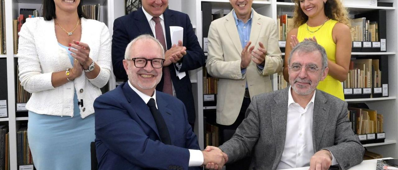 El director del Museo Reina Sofía, Borja-Villel (abajo a la derecha), y el coleccionista José María Lafuente se estrechan la mano tras firmar el contrato de compraventa del Archivo Lafuente, que pasa a manos del Estado, en presencia de autoridades regionales. | Efe |  EFE