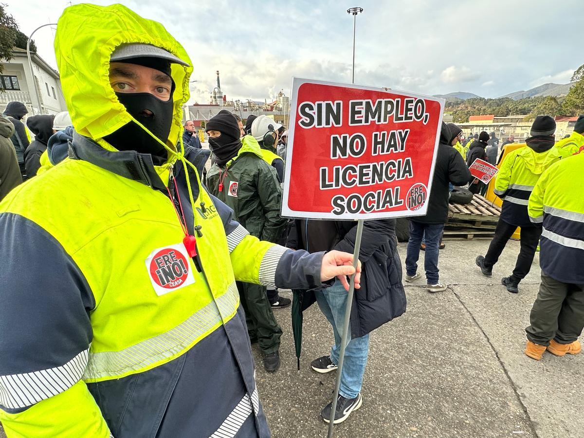 Un trabajador sostiene una pancarta durante la concentración contra el ERE que plantea la empresa, en Ence-Navia, este martes.