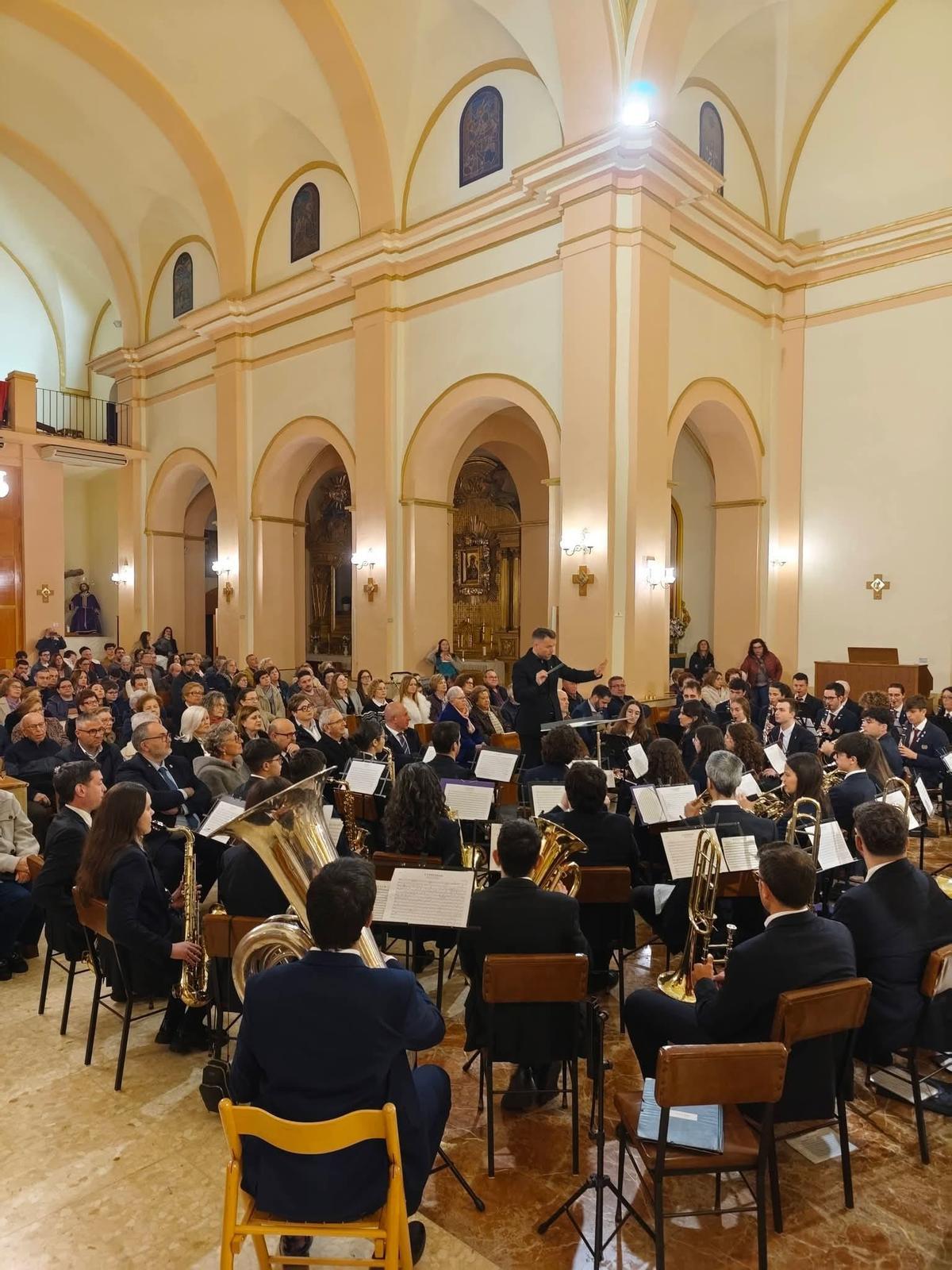 Los músicos atienden al director de la banda.