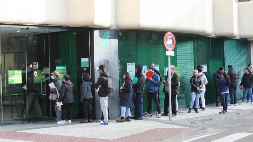 Filas en la oficina 8 Varias personas esperan en la calle para ser atendidas en la oficina de la Seguridad Social de la calle Doctor Cerrada de Zaragoza. | ÁNGEL DE CASTRO