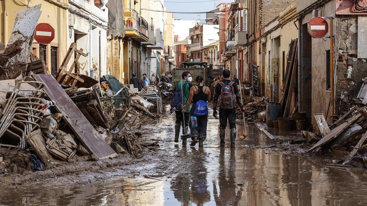 Varios voluntarios continuan con la limpieza de calles en el municipio de Paiporta.