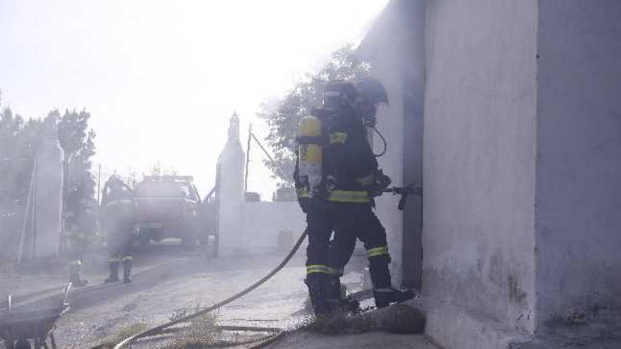 Un momento de la actuación de los bomberos en el incendio declarado ayer en las cercanías de la carretera de Almaraz