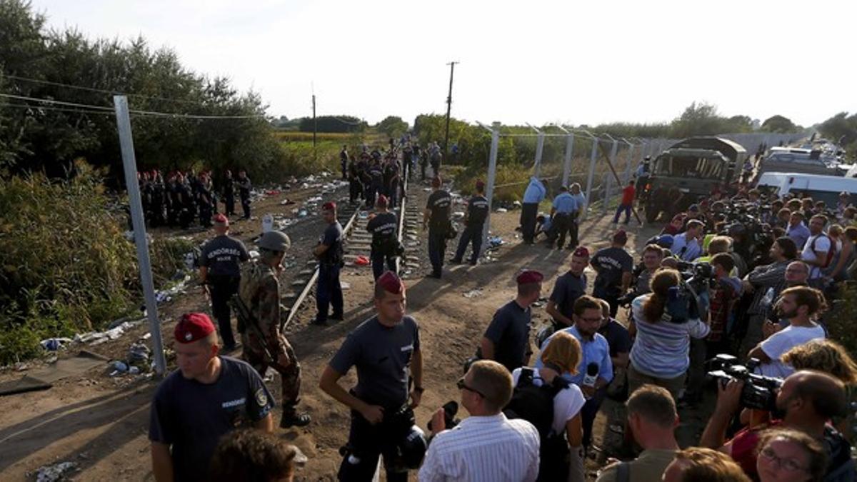 Policías húngaros forman una barrera humana para cortar el flujo de refugiados desde Serbia.