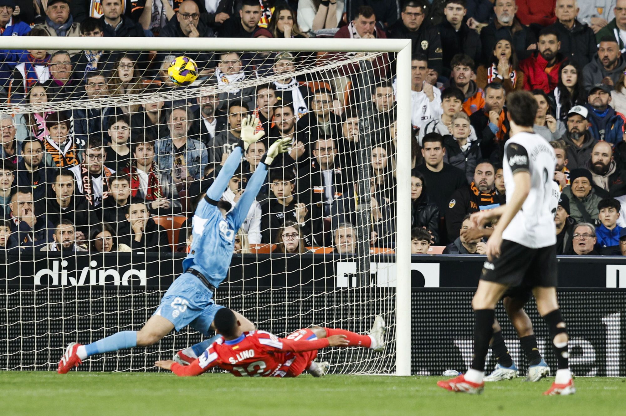 VALENCIA, 22/02/2025.- El guardameta georgiano del Valencia, Giorgi Mamardashvili, intenta detener el remate del delantero brasileño del Atlético de Madrid, Samuel Lino, durante el encuentro correspondiente a la jornada 25 de Laliga EA Sports que disputan hoy sábado Valencia y Atlético de Madrid en el estadio de Mestalla. EFE / Kai Forsterling.