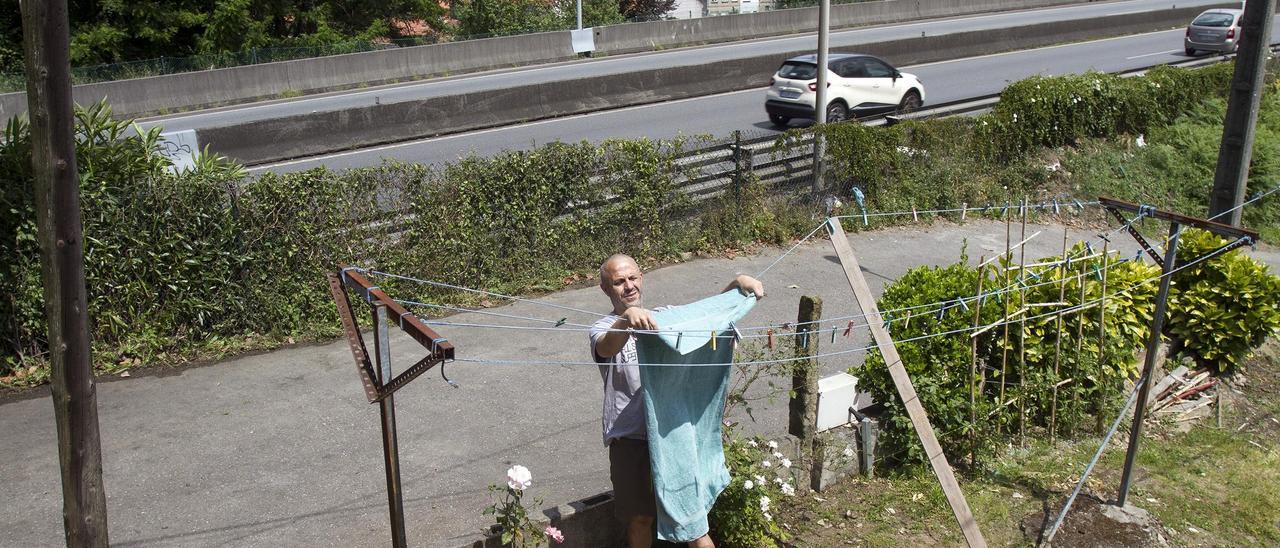 Imagen de archivo de un vecino en su casa tendiendo la ropa al pie de la AP-9.