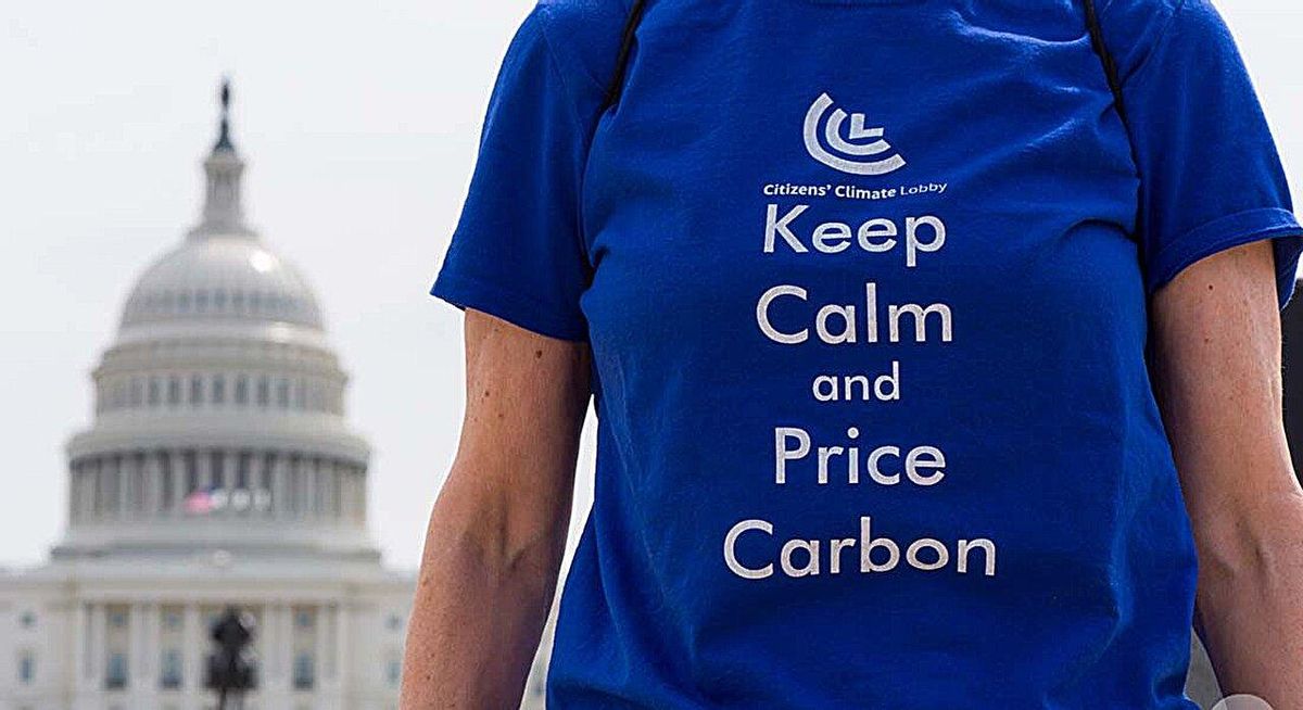 Un participante en la Marcha por el Clima de Washington en 2017, con una camiseta sobre el impuesto al carbono: "Mantengan la calma y pongan precio al carbono".