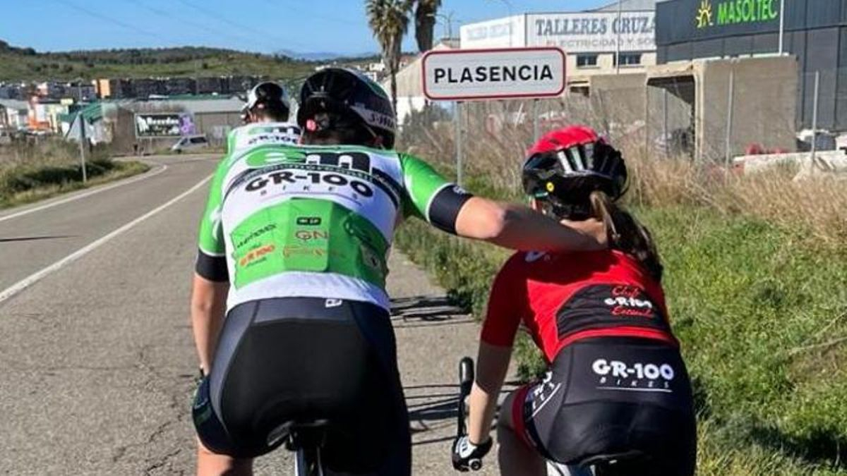 Un ciclista del  Electromercantil-GR100 junto a una niña de la escuela.