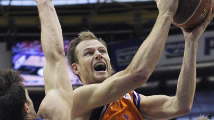 El alero australiano del Valencia Basket, Brad Newley (c), entran a canasta ante los jugadores del Barcelona Regal, Rabaseda (i) y el estadounidense C. J. Wallace.