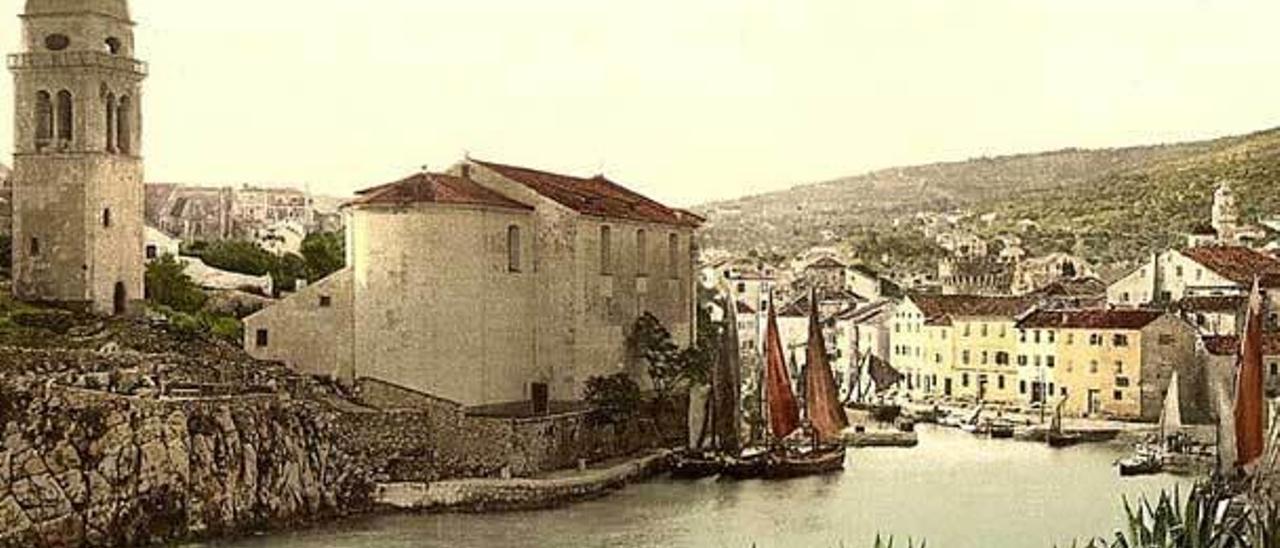 más de un siglo. Arriba, una pintura del puerto de Veli a principios del siglo XX, con la iglesia de San Antonio a la izquierda y, al fondo, tras los edificios, la torre medieval. Sobre estas líneas, Veli, el pasado verano.