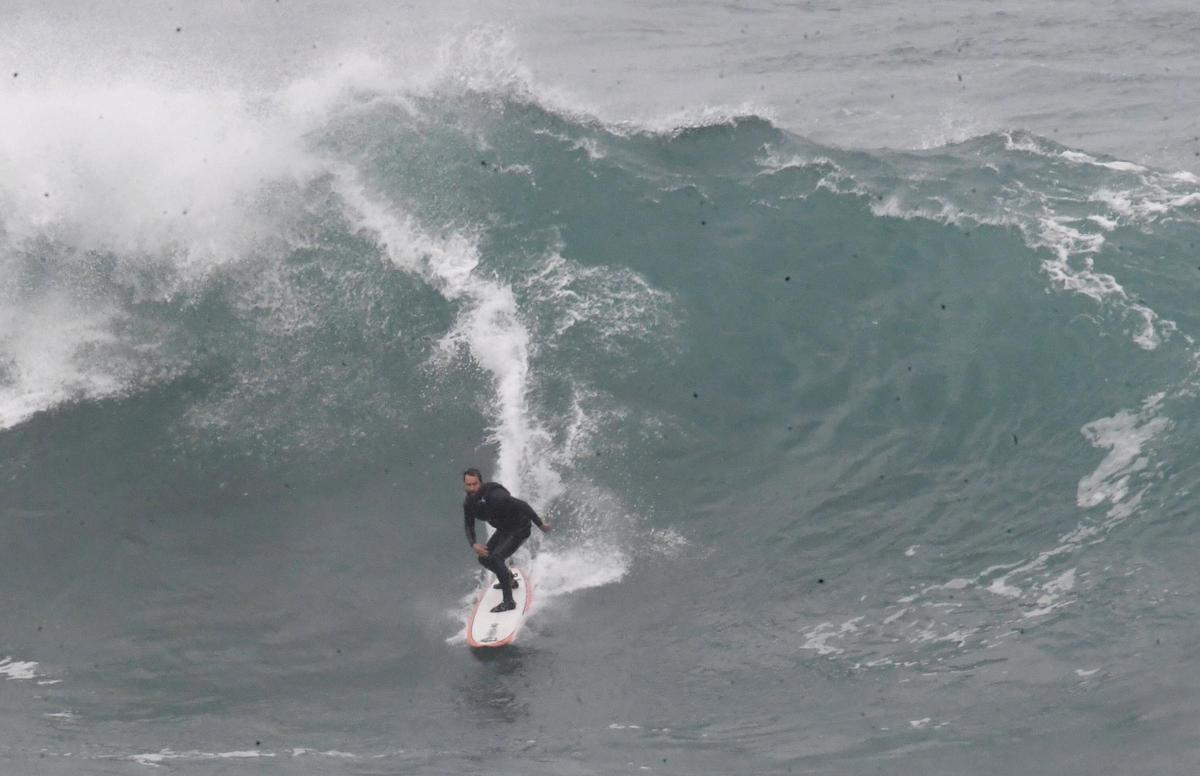 Un surfista practica el deporte en una playa coruñesa