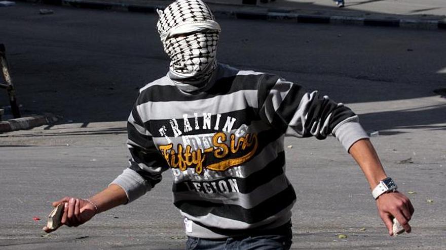 Un jóven lanza piedras a una patrulla del ejército israelí en la ciudad de Hebrón, Cisjordania hoy martes 11 de noviembre de 2008. Fuerzas del movimiento islamista Hamás impidieron hoy por la fuerza varias concentraciones del grupo rival Al-Fatah para conmemorar en Gaza el cuarto aniversario de la muerte del líder palestino Yaser Arafat. Testigos presenciales dijeron que milicianos de Hamás, unos vestidos de civil y otros de uniforme, se desplegaron por la franja para impedir las concentraciones de militantes de Al-Fatah, el movimiento nacionalista que Arafat presidió durante cuarenta años.