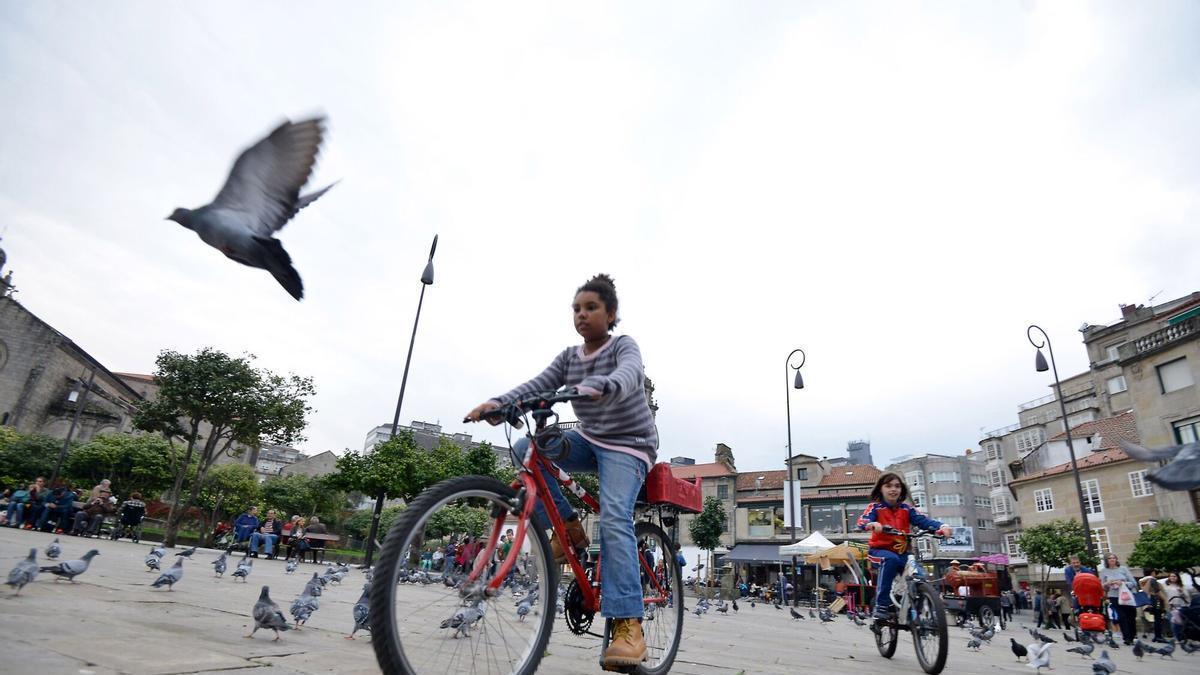 Niños jugando y paseando en bicicleta por la plaza de la Herrería.