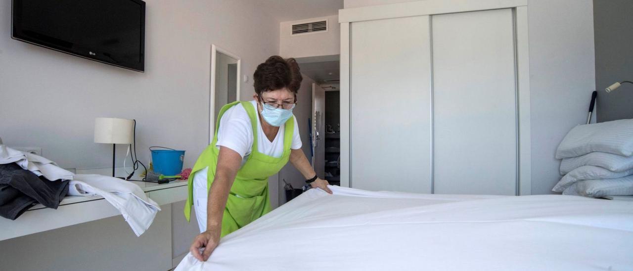 Una trabajadora hace la cama de un hotel. |   // DAVID ARQUIMBAU
