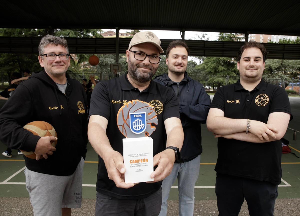 Por la izquierda, Héctor Colunga, Elías Montes, Bruno Ramos y Sergio Cuesta, con el trofeo de campeón regional, en el colegio Asturias.