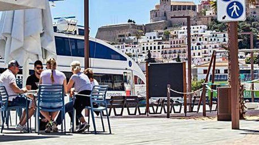 Un grupo de personas tomando el desayuno en la terraza de la estación marítima de Formentera, en el puerto de Ibiza.