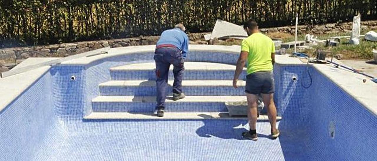 Dos operarios trabajan en la construcción de una piscina. |   // FDV