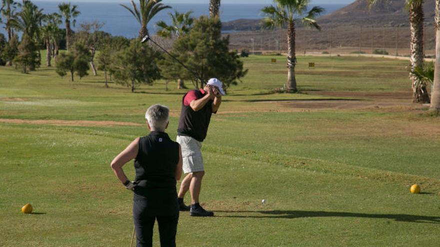 Dos personas juegan al golf en el club Amarilla Golf en San Miguel de Abona.