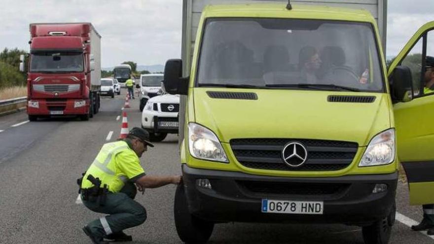 Dos agentes, controlando el estado de neumáticos y la documentación de un camión. // Brais L.