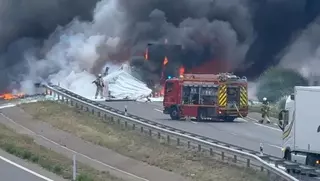 Así apagaba un bombero el fuego tras el accidente entre dos camiones que ha obligado a cortar la A-23
